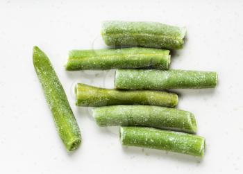 several cut and frozen green beans close up on gray ceramic plate