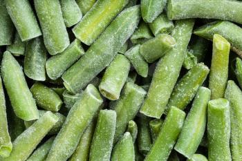 food background - many cut and frozen green beans close up