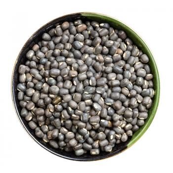 top view of raw whole black urad beans in round bowl isolated on white background