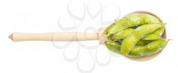 top view of frozen Edamame (unripe soybeans) pods in wood spoon isolated on white background