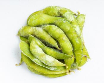 top view of pile of frozen Edamame (unripe soybeans) pods close up on gray ceramic plate