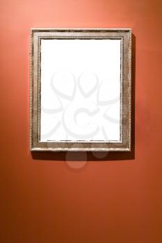 wide verical silver picture frame with cutout canvas on red brown wall