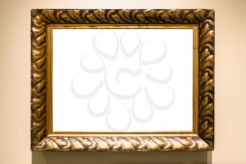 old carved wide bronze picture frame with cutout canvas on yellow brown wall