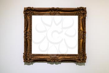 old decorated wide dark picture frame with cutout canvas on gray wall