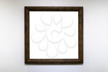 square dark brown picture frame with cutout canvas on white wall