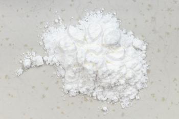 top view of pile of baking powder close up on gray ceramic plate