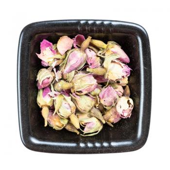 top view of old dried rosebuds in black bowl isolated on white background