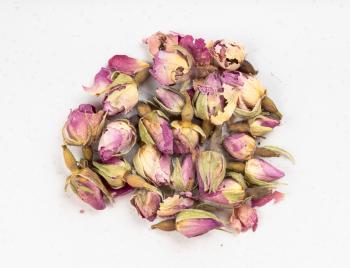 top view of pile of old dried rosebuds close up on gray ceramic plate