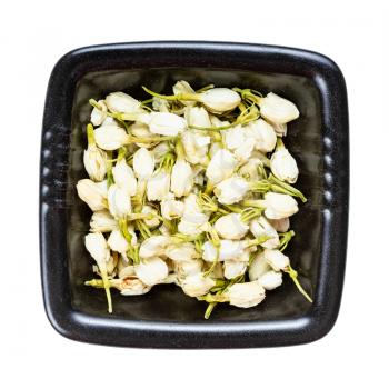 top view of dried jasmine flowers in black bowl isolated on white background