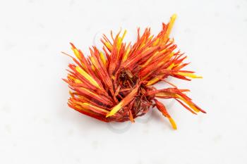 dried safflower bloom close up on gray ceramic plate