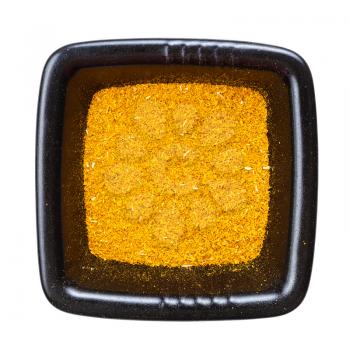 top view of ground dried tagetes (imeretian saffron) in black bowl isolated on white background