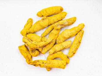 top view of pile of Turmeric (Curcuma) roots close up on gray ceramic plate