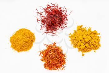 top view of saffron and its substitutes (crocus, turmeric, safflower, tagetes) on white plate