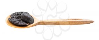 dried tonka beans in wooden spoon isolated on white background