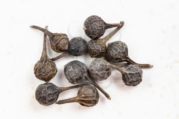 several tailed pepper (cubeb) close up on gray ceramic plate