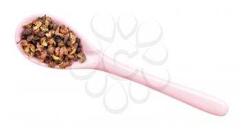 top view of dried pink sichuan pepper in ceramic spoon isolated on white backgrouns