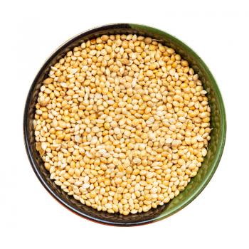 top view of unpolished yellow proso millet in round bowl isolated on white background