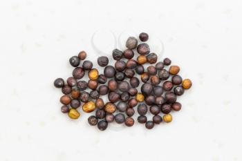 several whole-grain rapeseeds close up on gray ceramic plate