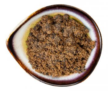 top view of muscovado dark brown cane sugar in ceramic bowl isolated on white background