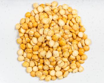 top view of pile of raw dried split yellow peas close up on gray ceramic plate