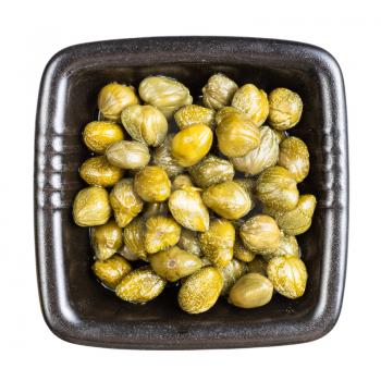 top view of pickled capers in black bowl isolated on white background