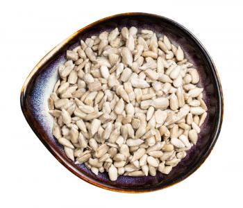 top view of peeled sunflower seeds in ceramic bowl isolated on white background