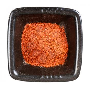 top view of paprika powder in black bowl isolated on white background