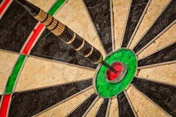 Success hitting target aim goal achievement concept background - dart in bull's eye close up