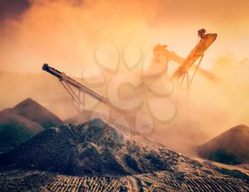 Vintage retro effect filtered hipster style image of Industrial hell pollution concept - crusher rock stone crushing machine at open pit mining and processing plant for crushed stone sand and gravel