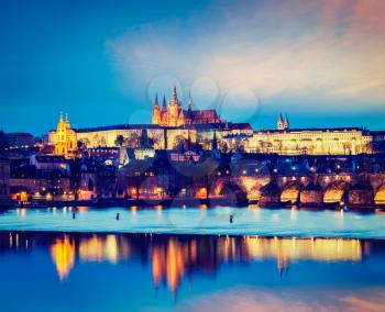 Vintage retro hipster style travel image of travel Prague Europe concept background - view of Charles Bridge and Prague Castle in twilight. Prague, Czech Republic