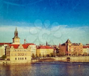 Vintage retro hipster style travel image of Prague Stare Mesto embankment view from Charles bridge on sunset with grunge texture overlaid. Prague, Czech Republic