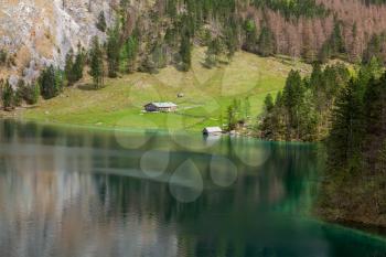 Farm house on mountain lake Obersee lake in spring. Bavaria, Germany