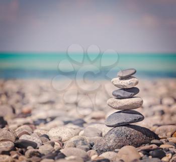 Vintage retro hipster style travel image of Zen meditation background -  balanced stones stack close up on sea beach