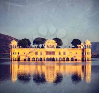 Vintage retro hipster style travel image of Rajasthan landmark - Jal Mahal (Water Palace) on Man Sagar Lake on sunset.  Jaipur, Rajasthan, India with grunge texture overlaid