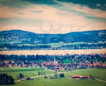 Vintage retro hipster style travel image of German countryside and village. Bavaria, Germany