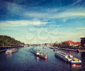 Vintage retro hipster style travel image of turist boats on Vltava river in Prague, Czech Republic with grunge texture overlaid