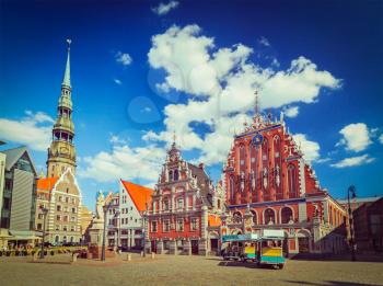 Vintage retro hipster style travel image of 
Riga Town Hall Square, House of the Blackheads and St. Peter's Church, Riga, Latvia