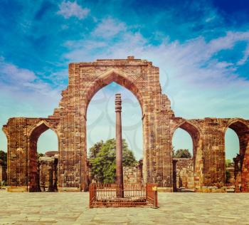Vintage retro effect filtered hipster style travel image of Iron pillar in Qutub complex - metallurgical curiosity.  Qutub Complex, Delhi, India