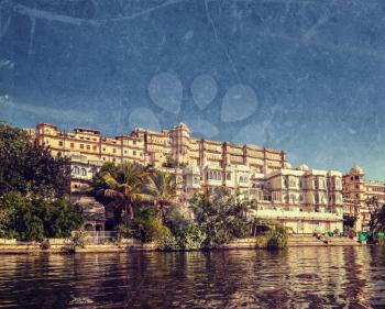 Vintage retro hipster style travel image of India luxury tourism concept background - Udaipur City Palace from Lake Pichola with grunge texture overlaid. Udaipur, Rajasthan, India