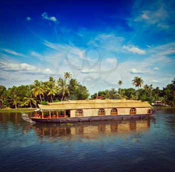 Vintage retro hipster style travel image of Kerala travel tourism background - houseboat on Kerala backwaters. Kerala, India
