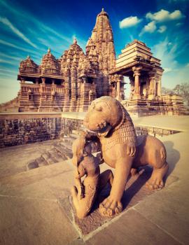 King and lion fight statue and Kandariya Mahadev temple.  Khajuraho, India
