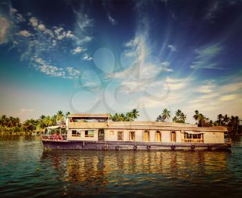 Vintage retro hipster style travel image of travel tourism Kerala background - houseboat on Kerala backwaters. Kerala, India