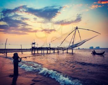 Vintage retro hipster style travel image of Kochi chinese fishnets on sunset. Fort Kochin, Kochi, Kerala, India