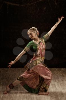 Vintage retro style image of young beautiful woman dancer exponent of Indian classical dance Bharatanatyam