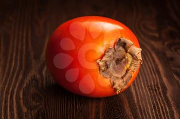 Fresh ripe persimmon on a wooden background