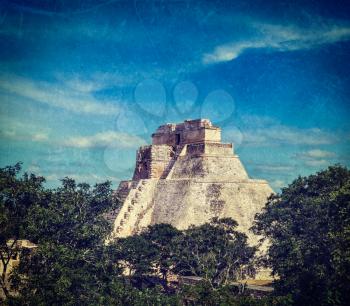 Vintage retro hipster style travel image of anicent mayan pyramid (Pyramid of the Magician, Adivino) in Uxmal, Merida, Yucatán, Mexico with grunge texture overlaid