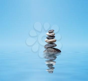 Zen meditation background -  balanced stones stack in water with reflection