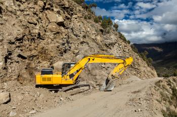 Road construction in mountains Himalayas - excavator. Lahaul valley, Himachal Pradesh, India