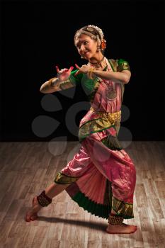 Young beautiful woman dancer exponent of Indian classical dance Bharatanatyam in Krishna pose