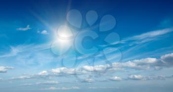 Sun with clouds in blue sky